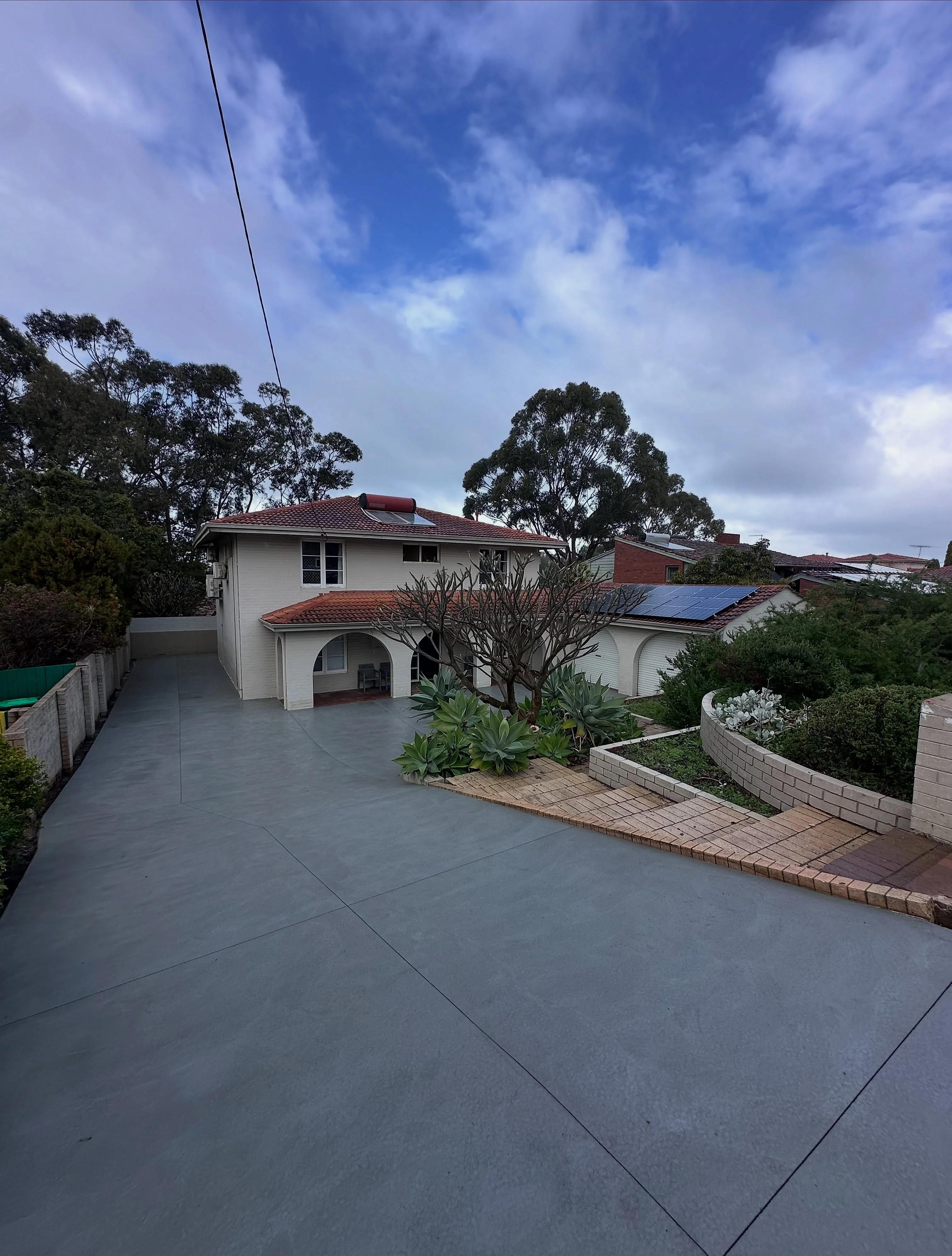 Old bitumen driveway ripped out and replaced with non-slip grey concrete, full width from crossover to garage
