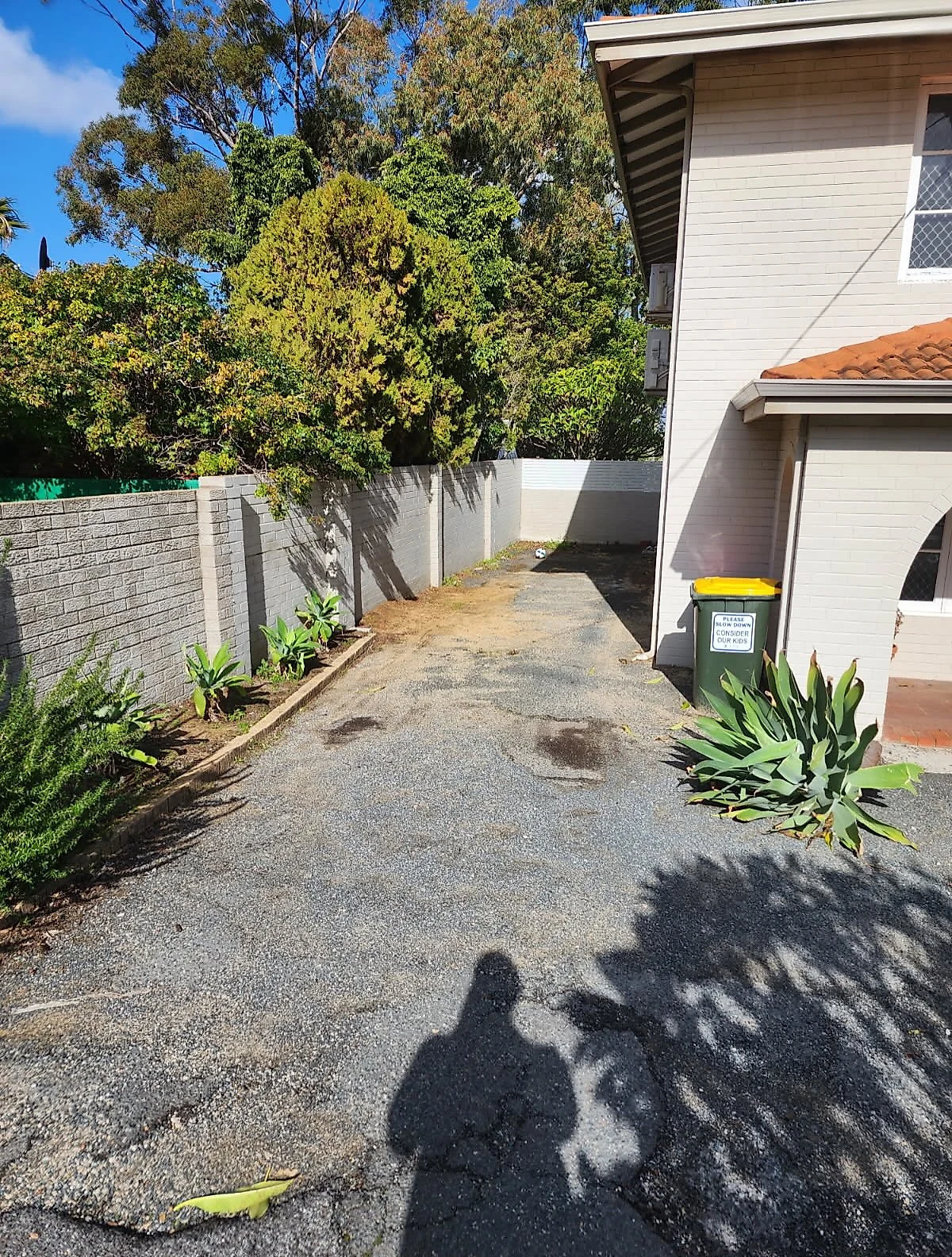 Before: Old bitumen driveway ripped out and replaced with non-slip grey concrete, full width from crossover to garage