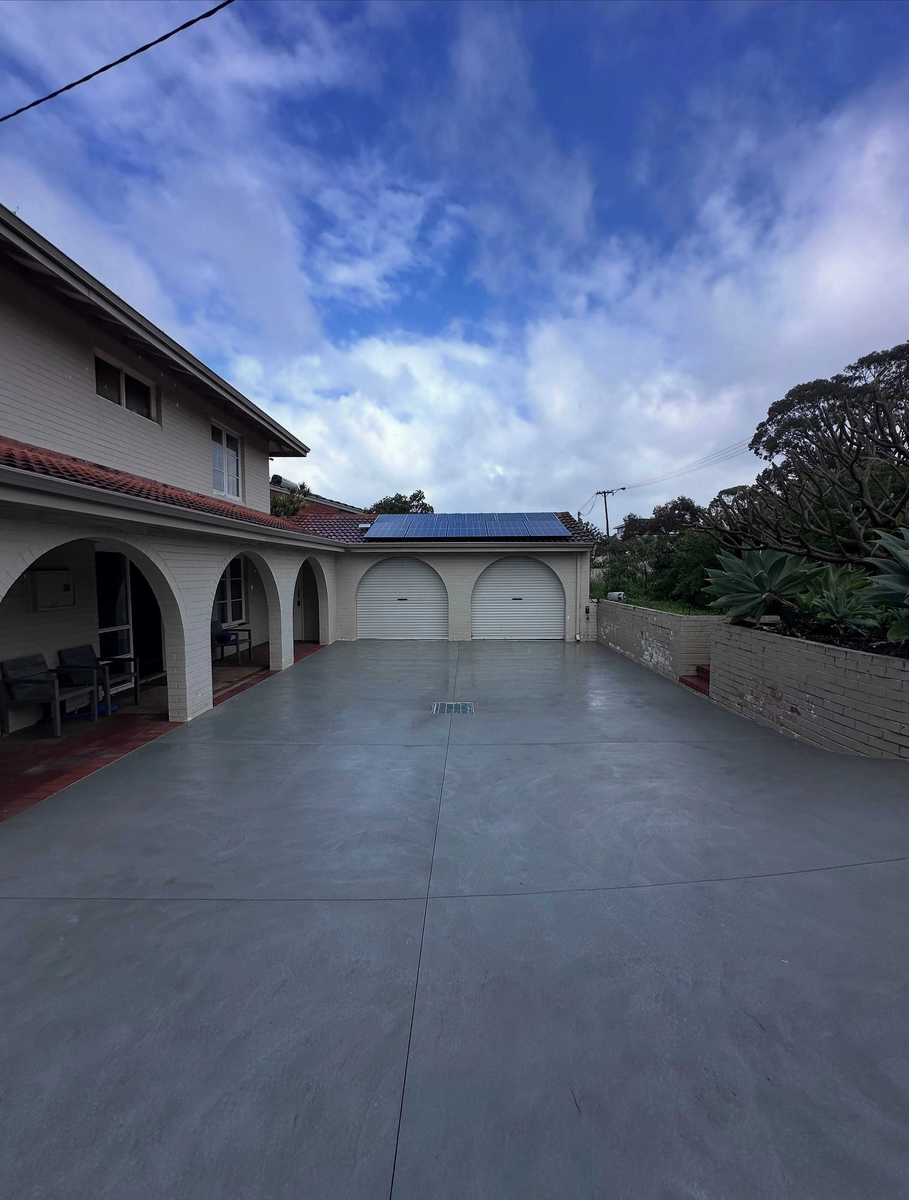 Non-slip grey concrete driveway replacing failed bitumen in Karrinyup, full width from crossover to garage on 