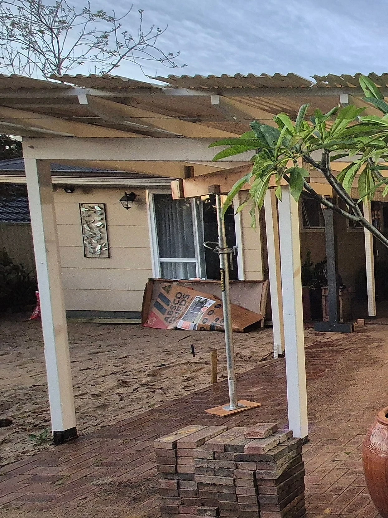 Before: a Trigg back yard of sand and old brick paving, replaced with a honed concrete pool surround