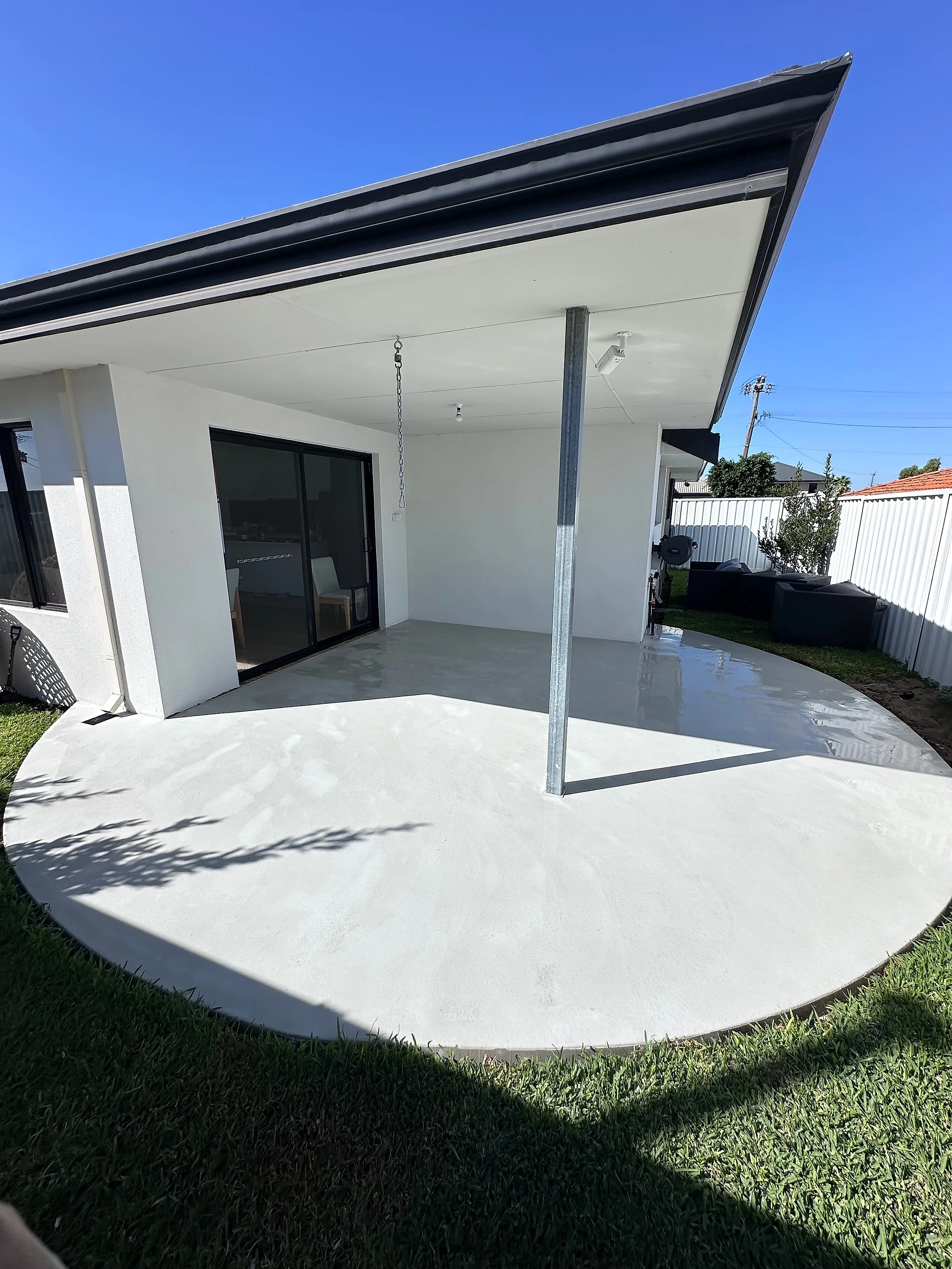 A curved alfresco slab in Holcim Geostone architectural white, run to a radius at the open edge rather than a 