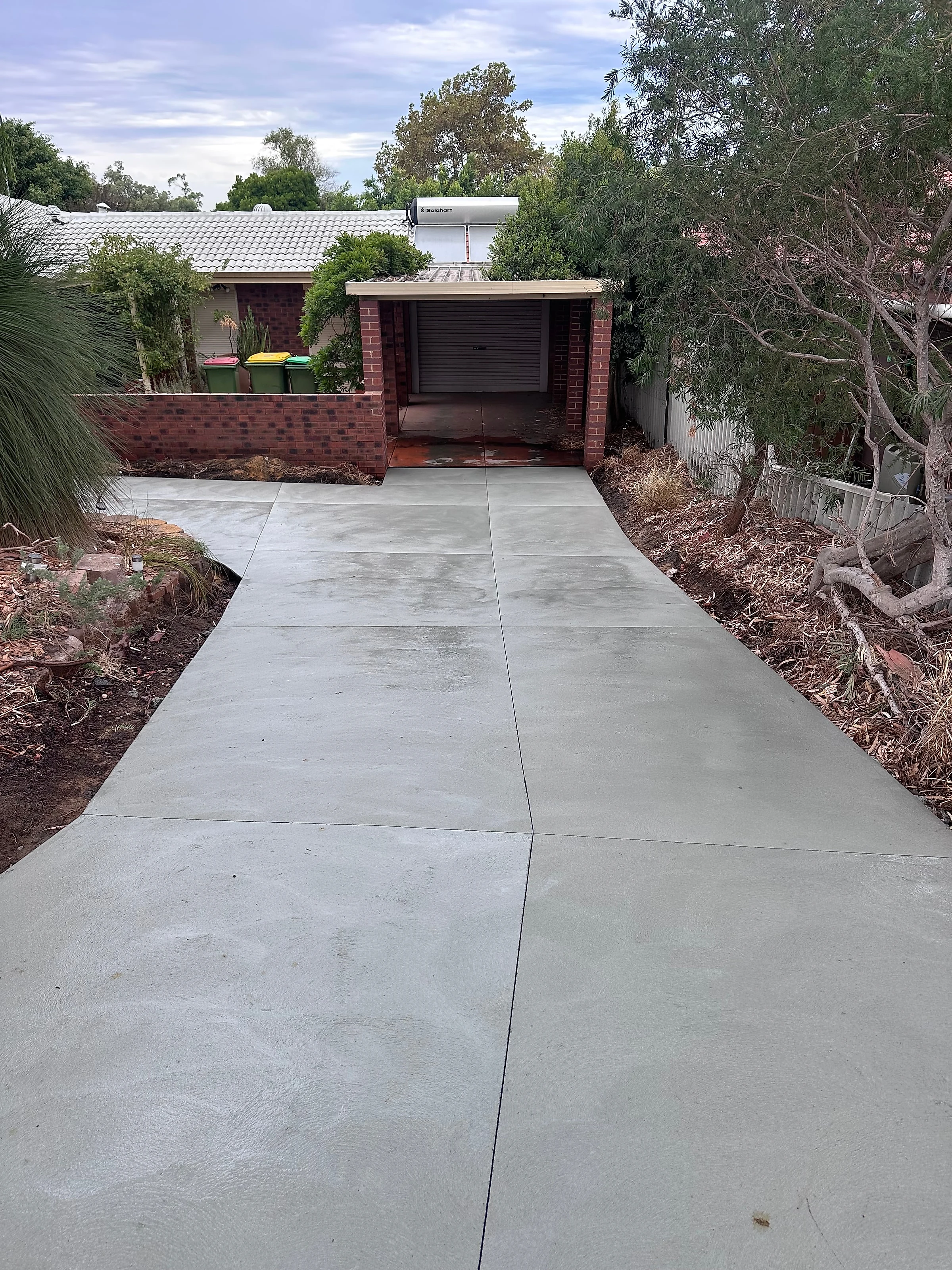 Standard grey driveway, curved to follow the garden bed