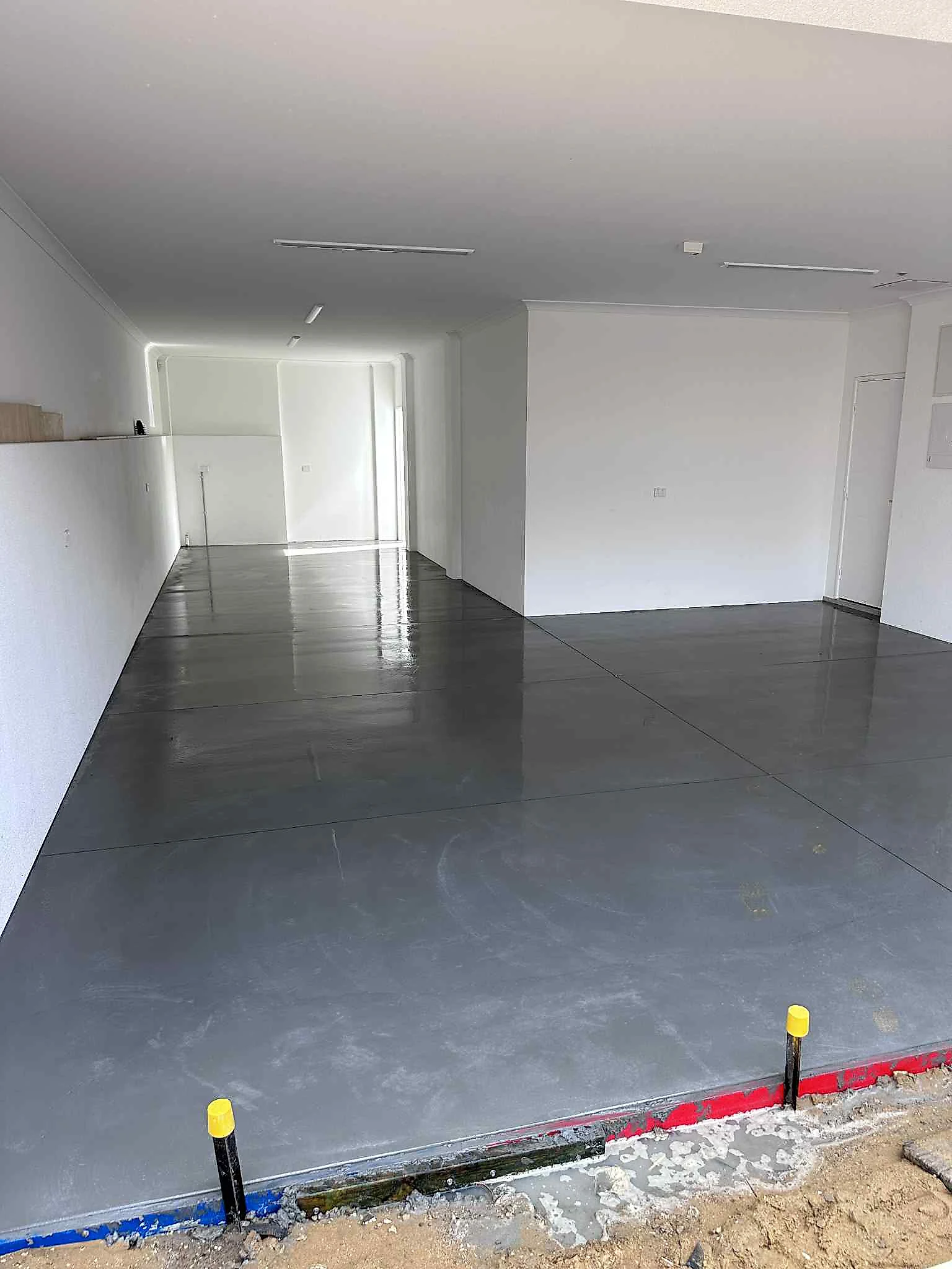 Sealed indoor floor run right up to the walls with no skirting shadow line