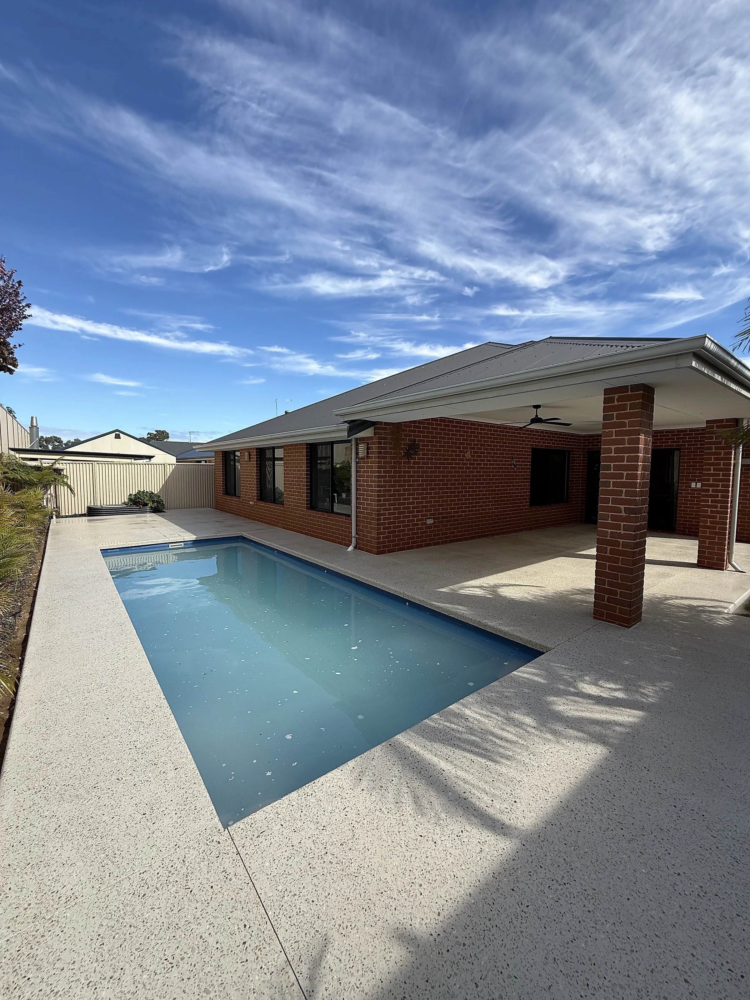 An exposed aggregate pool surround and covered alfresco at a Sorrento home in Limecrete Coral White, washed of