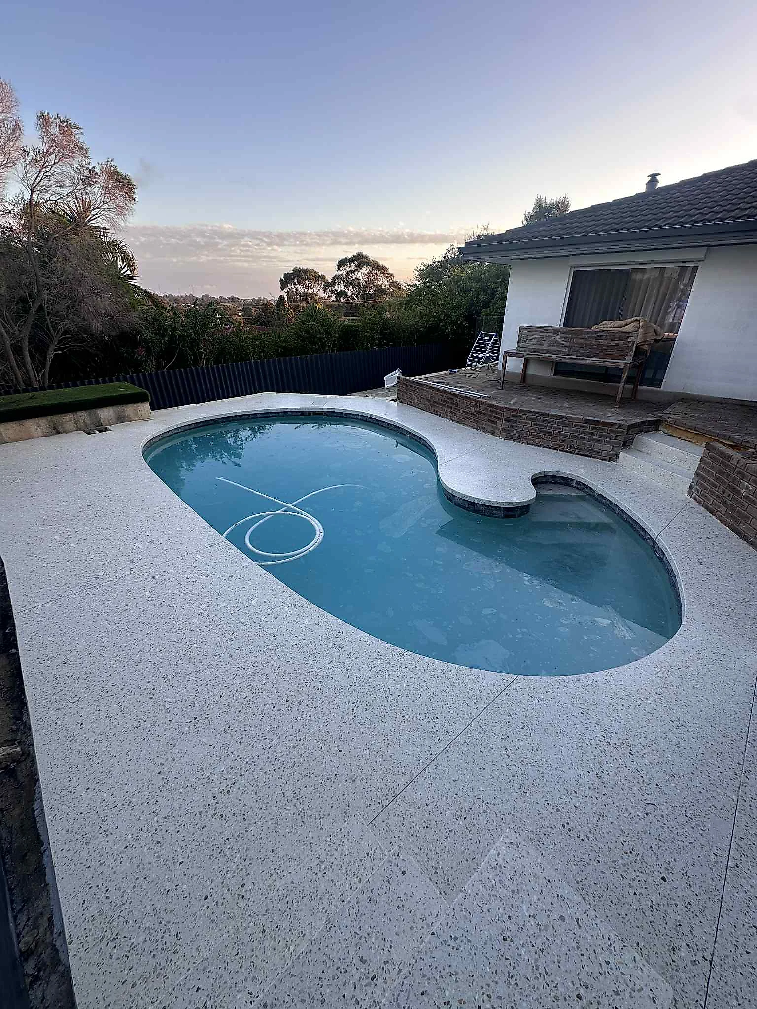 Honed concrete pool surround in Duncraig with decking to one side, levels set so the two materials meet flush