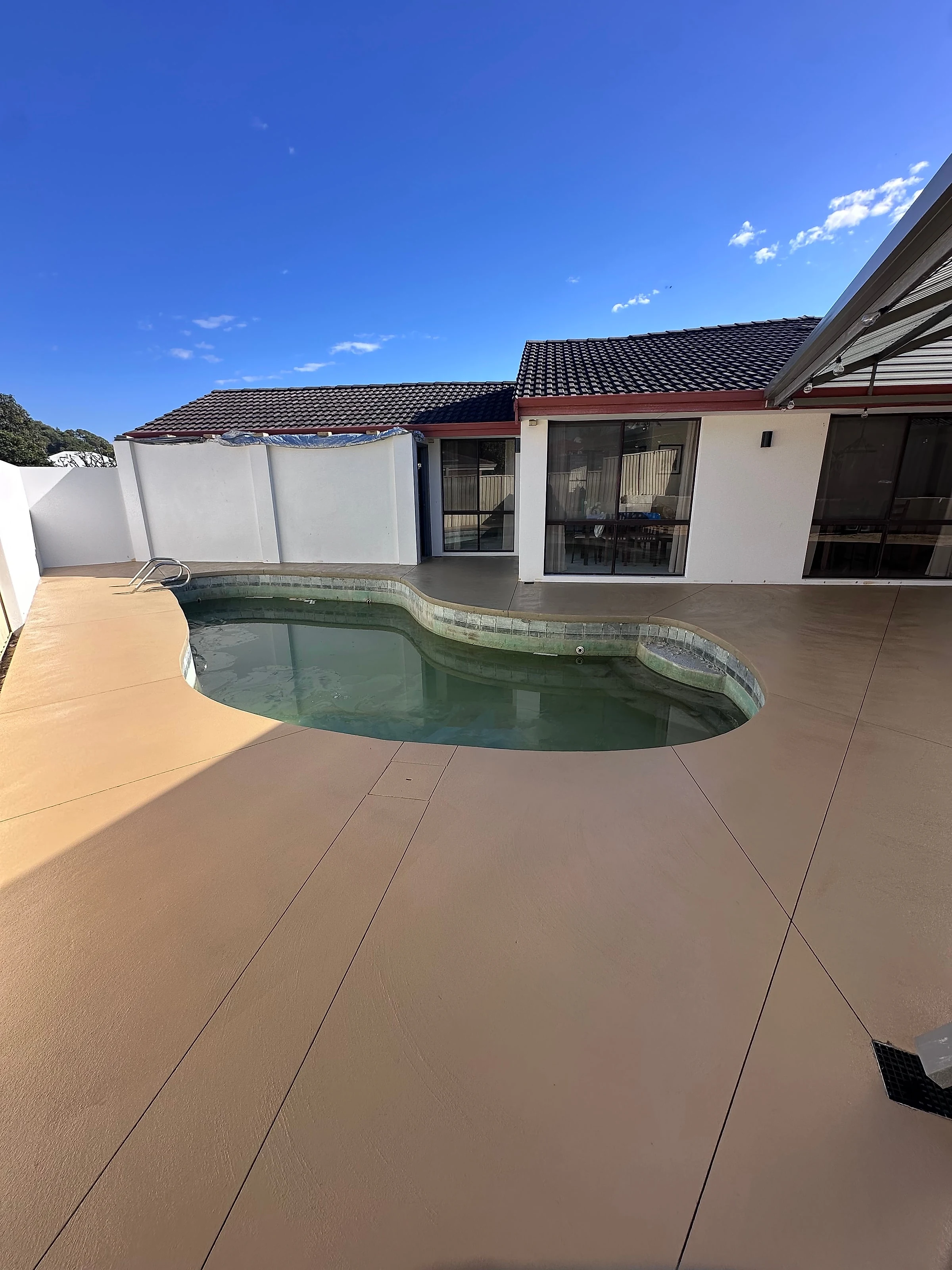 Tan coloured surround wrapping a curved pool
