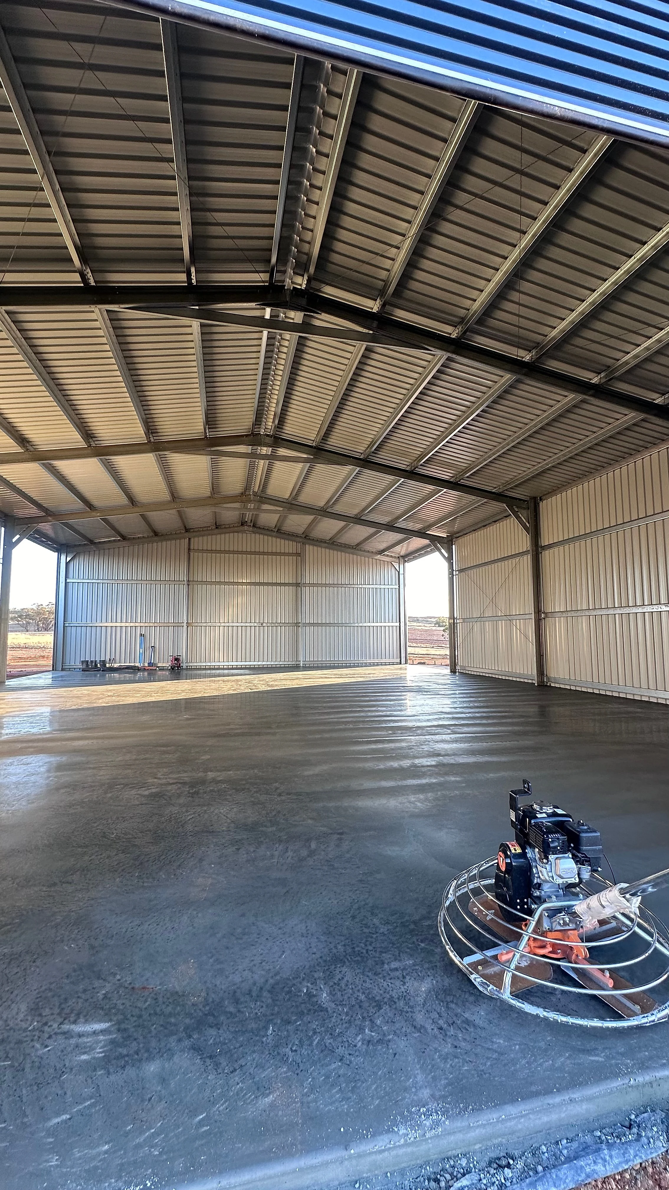 Floors poured inside large portal frame sheds, run wall to wall and trowelled flat enough to take racking, a f